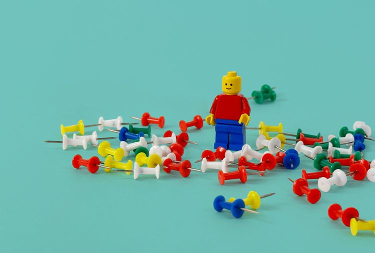 Lego character surrounded by push pins