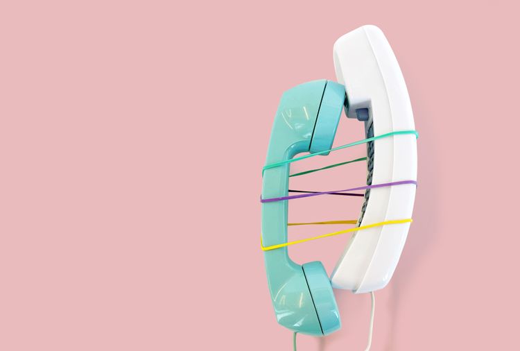 Green and white phones tied together with rubber bands